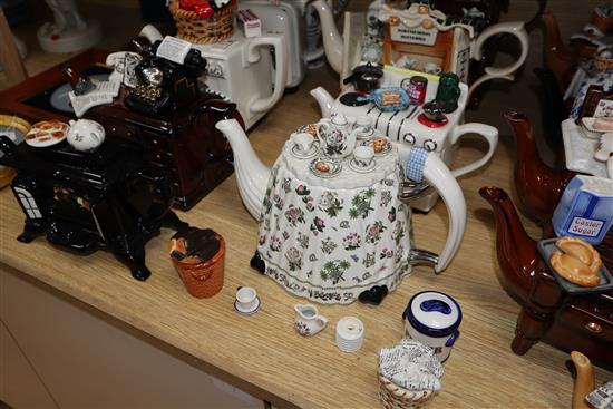 A collection of thirteen Portmeirion and Cardew novelty teapots, including dresser, sewing machine and kitchen range examples